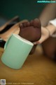 A woman's feet in a cup of coffee on a table.