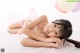A young girl laying on the floor with balloons in the background.