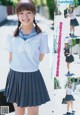 A young woman in a school uniform is posing for a picture.