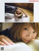 A woman laying on top of a bed next to a book.