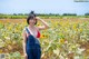 A woman standing in a field of sunflowers.