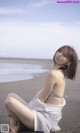 A woman sitting on a beach next to the ocean.