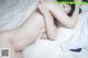 A naked woman laying on a bed with a white sheet.