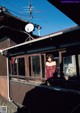 A woman standing on a balcony looking out of a window.