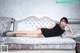 A woman laying on top of a white couch.